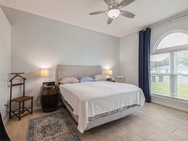 bedroom featuring a textured ceiling, light hardwood / wood-style flooring, and ceiling fan