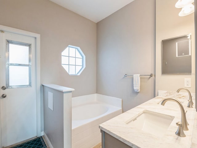 bathroom with vanity and a relaxing tiled tub