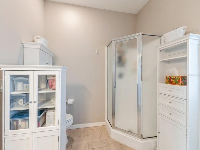 bathroom with toilet and an enclosed shower