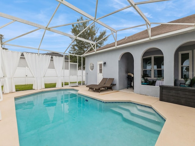 view of swimming pool with glass enclosure and a patio area