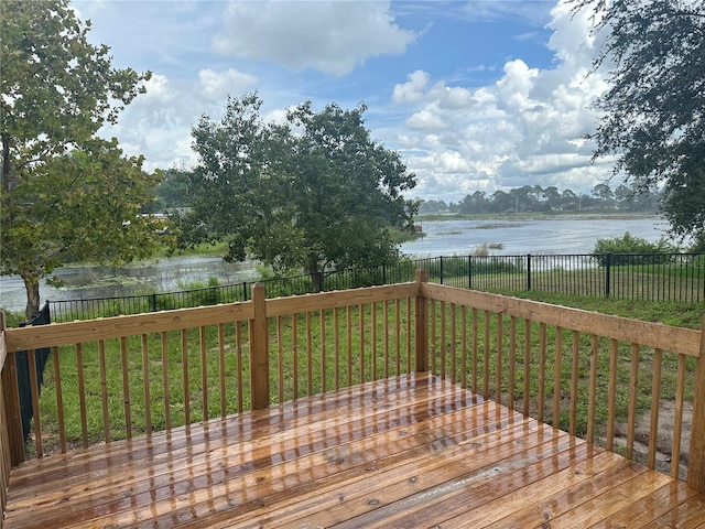 wooden deck featuring a yard, a water view, and a fenced backyard