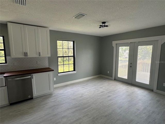 unfurnished dining area with a wealth of natural light, visible vents, and light wood-type flooring