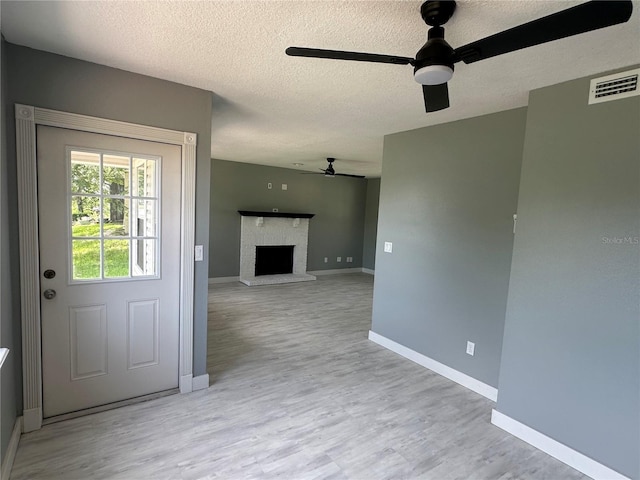 interior space featuring visible vents, baseboards, wood finished floors, and a fireplace