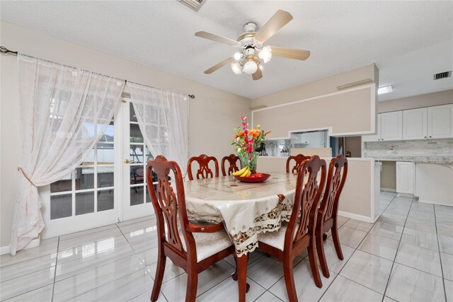 tiled dining space featuring a textured ceiling and ceiling fan