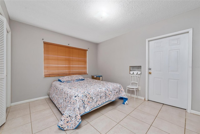 bedroom featuring a textured ceiling and light tile patterned flooring