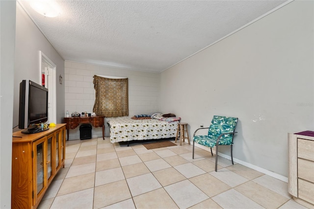 bedroom with a textured ceiling and light tile patterned floors