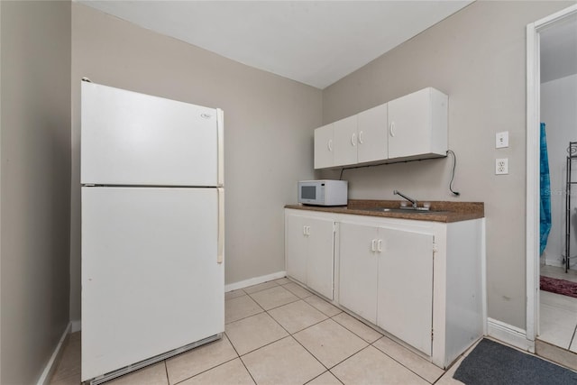 kitchen featuring sink, white appliances, white cabinetry, and light tile patterned flooring