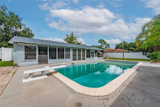 view of pool featuring a sunroom, a diving board, and a patio area