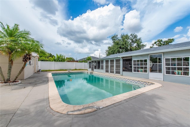 view of swimming pool with a sunroom and a patio