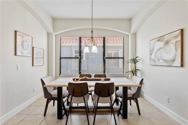 dining room with light tile patterned flooring and a notable chandelier