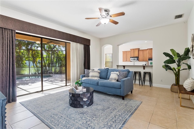 tiled living room with ceiling fan