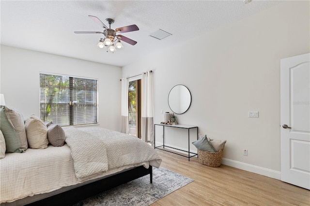 bedroom with light wood-type flooring, a textured ceiling, and ceiling fan