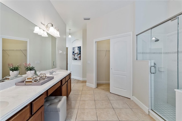 bathroom with tile patterned floors, walk in shower, and vanity