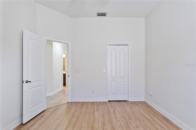 unfurnished bedroom featuring a closet and light hardwood / wood-style floors