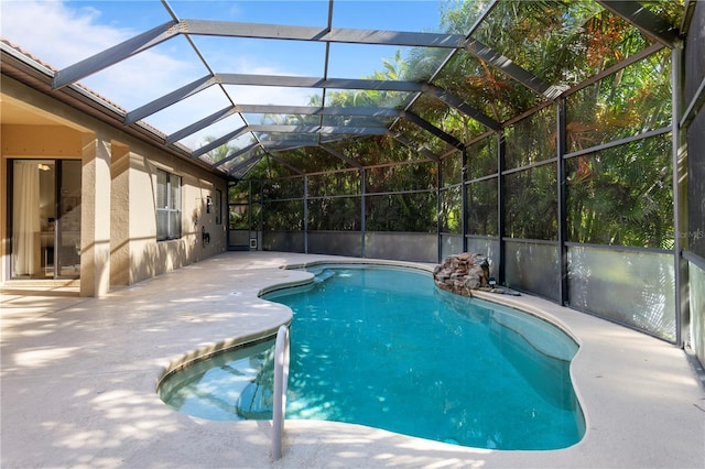 view of swimming pool with glass enclosure and a patio area