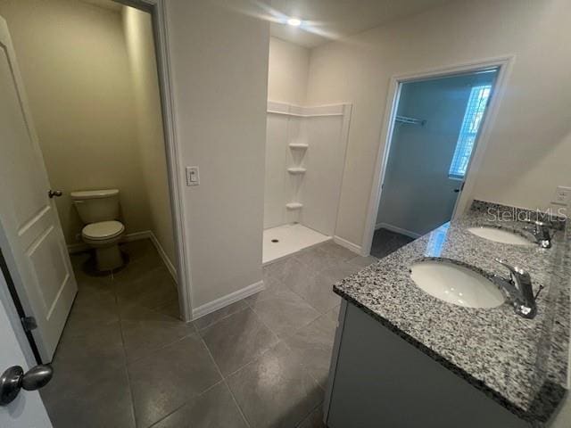 bathroom featuring a shower, toilet, and vanity