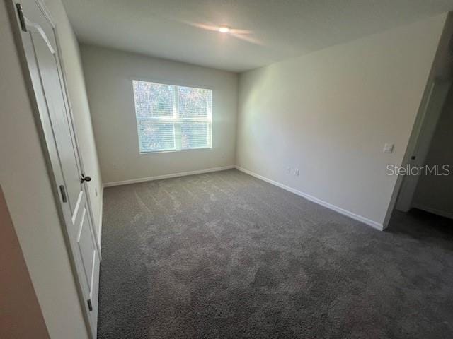 empty room with dark carpet