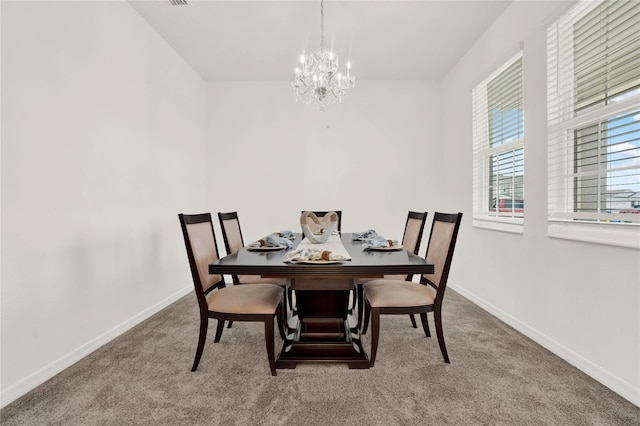 carpeted dining area featuring a chandelier