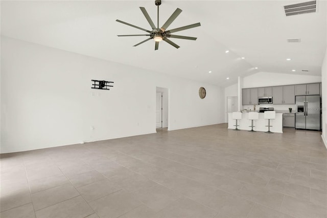 unfurnished living room featuring ceiling fan, lofted ceiling, and light tile patterned floors