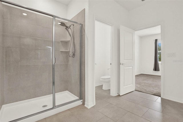 bathroom featuring tile patterned floors, an enclosed shower, and toilet