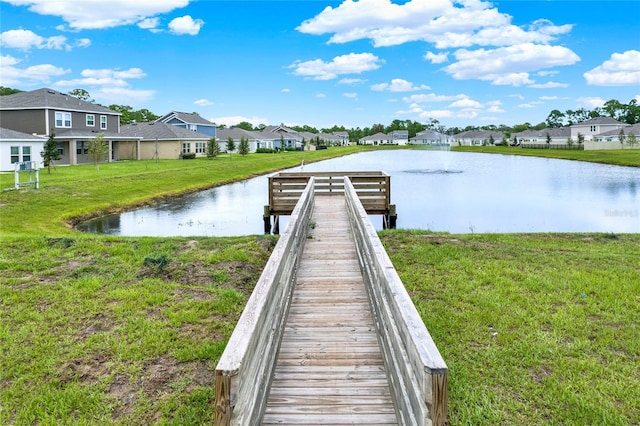 dock area with a yard and a water view