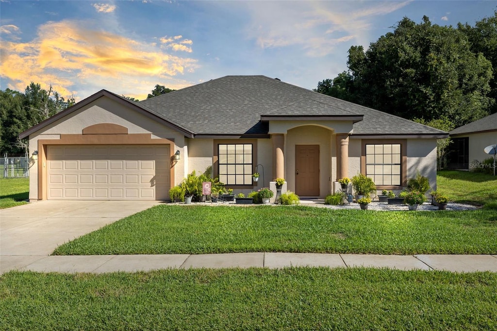 view of front of property with a garage and a yard