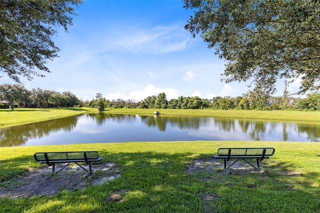 view of property's community with a lawn and a water view