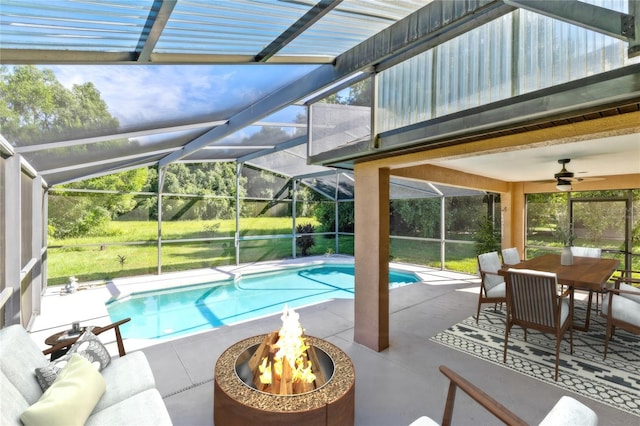 view of pool featuring a lanai, ceiling fan, an outdoor living space with a fire pit, and a patio