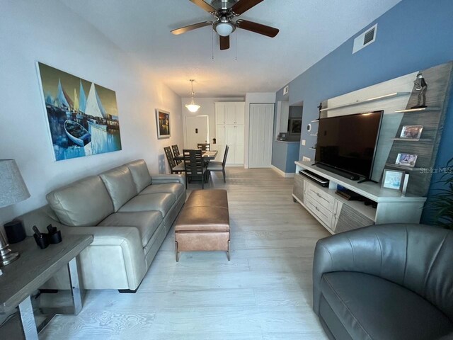 living room with ceiling fan and light hardwood / wood-style flooring