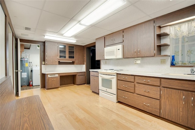 kitchen featuring electric water heater, a paneled ceiling, light hardwood / wood-style floors, and white appliances