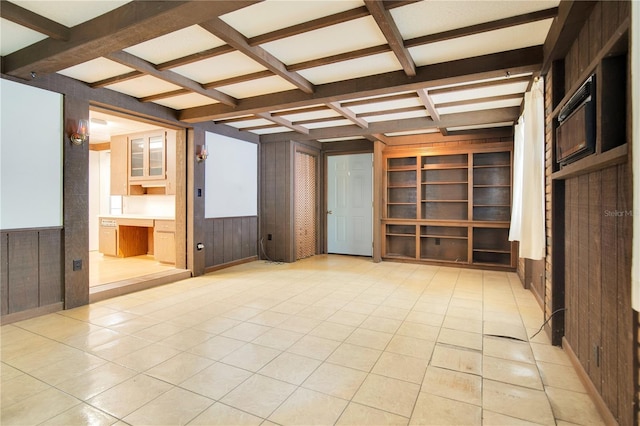 interior space featuring coffered ceiling, light tile patterned flooring, wood walls, and beam ceiling