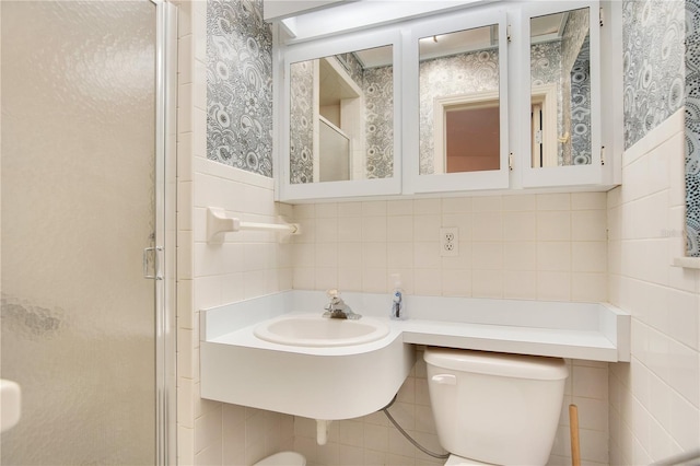 bathroom with tile walls, a shower with door, and toilet