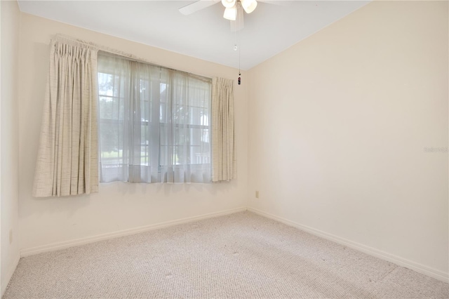 carpeted spare room featuring ceiling fan