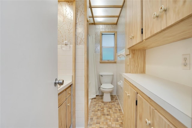 bathroom featuring tile patterned flooring, toilet, curtained shower, tile walls, and vanity