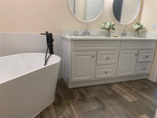 bathroom with vanity, hardwood / wood-style floors, and a bathing tub