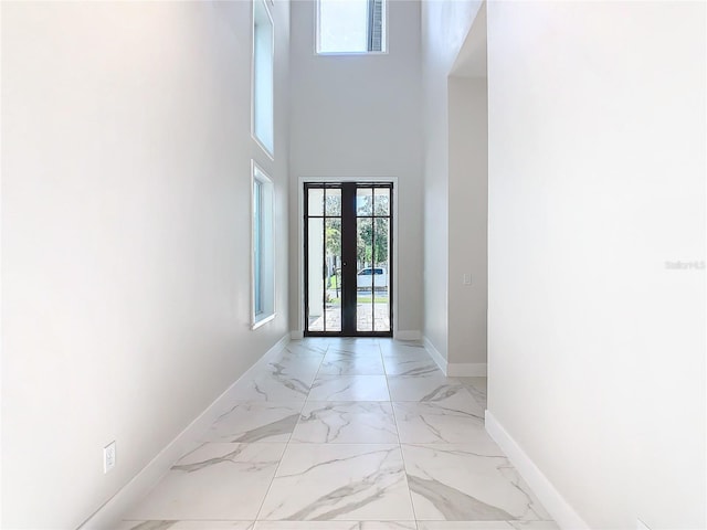 entryway featuring french doors and a towering ceiling