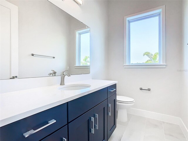 bathroom featuring vanity, toilet, tile patterned floors, and plenty of natural light