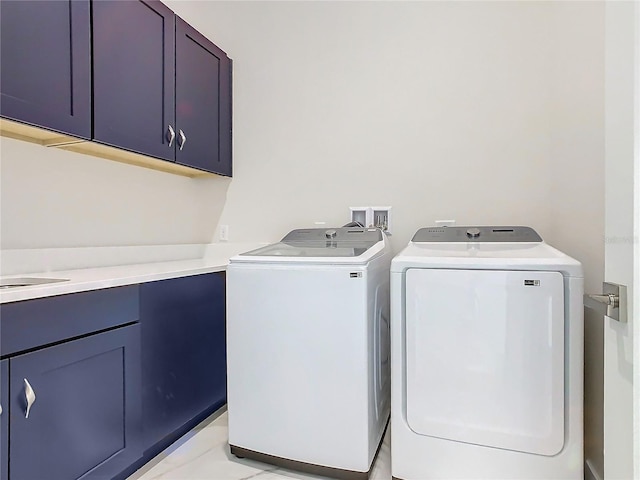 clothes washing area with cabinets, washing machine and dryer, and light tile patterned flooring