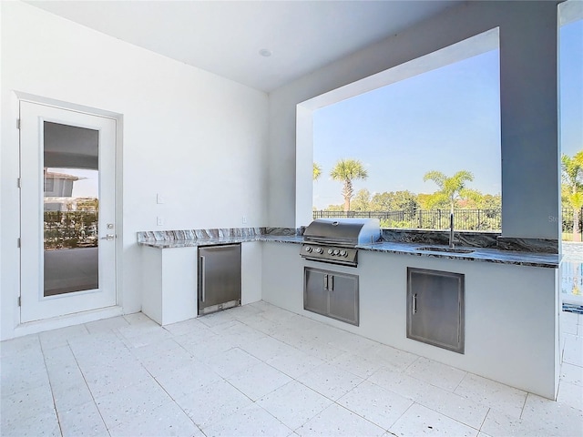 view of patio featuring area for grilling, sink, and exterior kitchen