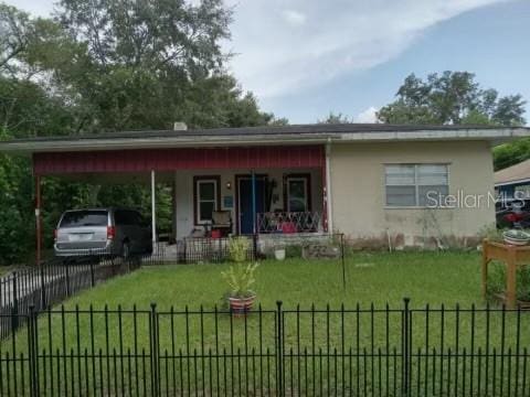 view of front of house with a front yard, covered porch, and a carport