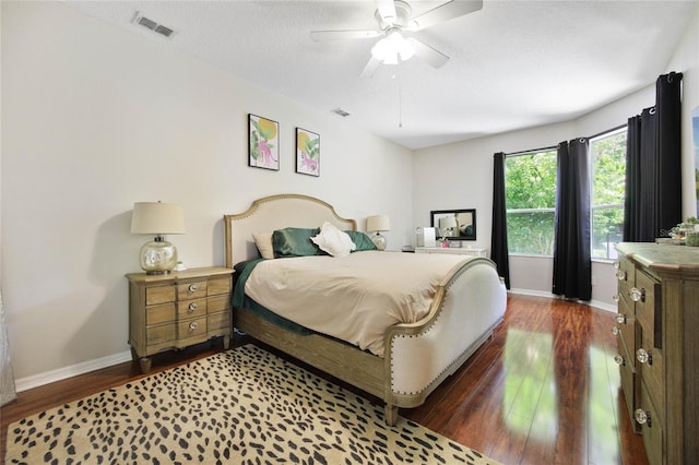 bedroom featuring a textured ceiling, ceiling fan, and dark hardwood / wood-style floors