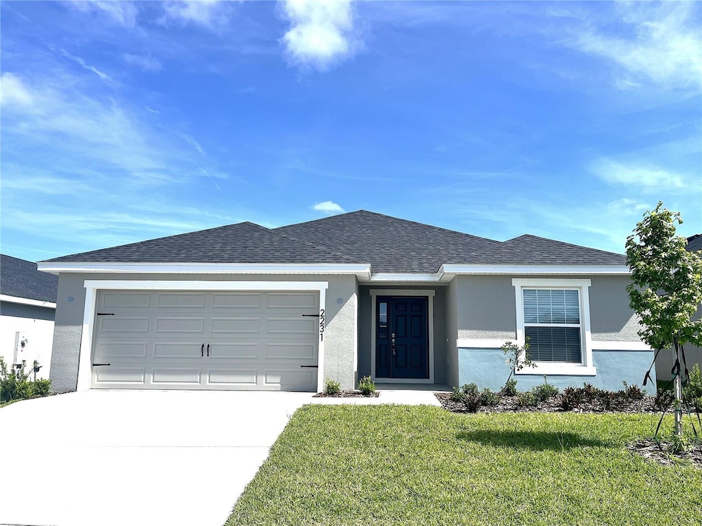 view of front of property with a front lawn and a garage