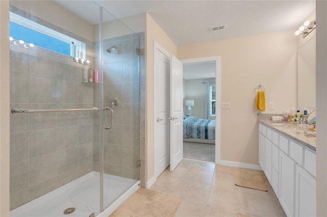 bathroom with vanity, an enclosed shower, and tile patterned flooring