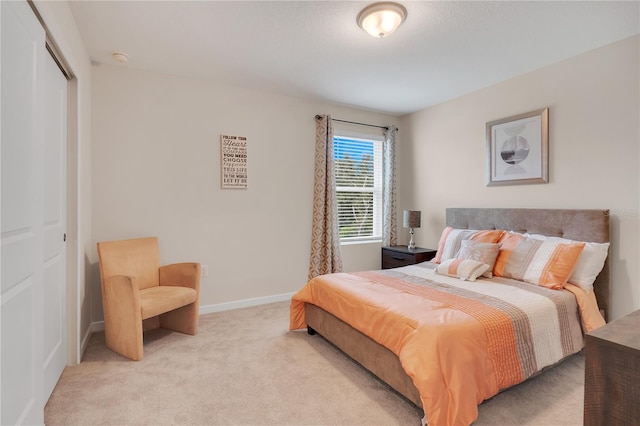 bedroom featuring light carpet and a closet