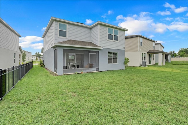 rear view of property featuring central AC, a sunroom, and a lawn