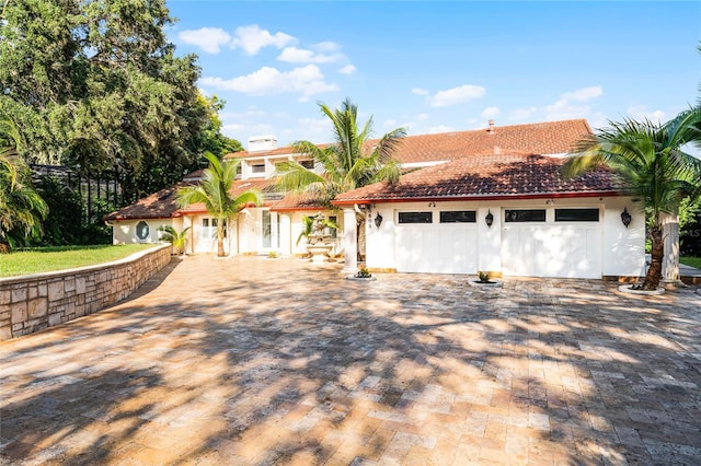 8605 Bay Shore Cv, Orlando, FL 32836 - mediterranean / spanish house featuring stucco siding, decorative driveway, a garage, a tiled roof, and fence