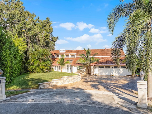 mediterranean / spanish-style house with a garage and a front yard