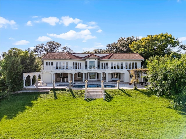 back of property with a lawn and a patio