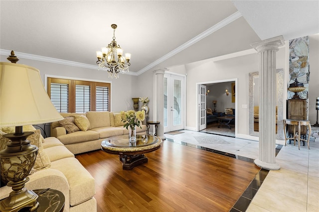 living room with a notable chandelier, lofted ceiling, decorative columns, light hardwood / wood-style flooring, and crown molding