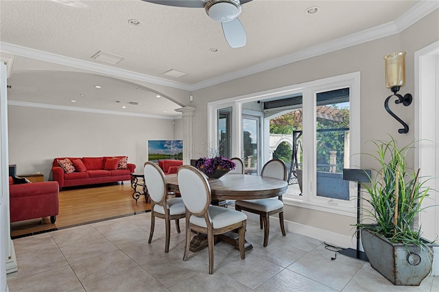 dining space featuring ornamental molding, light tile patterned flooring, and decorative columns